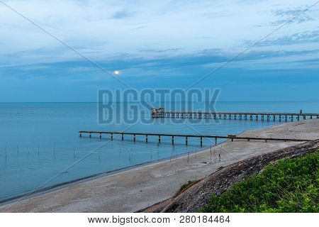 Beach, Bridge And The Moon Is Rising At 
Nim Seng Beach, Songkhla, Thailand.