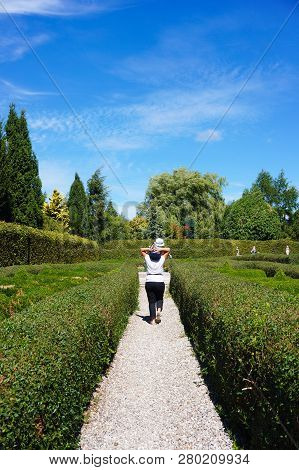 Dobrzyca, Poland - August 6, 2018: Woman Walking With Toddler On Her Shoulders In A Labyrinth At The