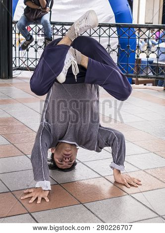 Cuenca, Ecuador - August 13, 2015 - Teenage Boy Practices Break Dance Head Stand In The Park