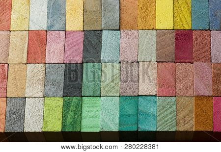 Abstract back ground, consisting of hand painted colored wooden cubes.  warm earth colors or neutral colors. grey pale pink, green, beige.