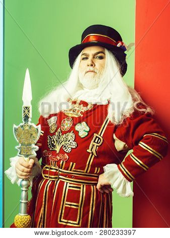 Proud Senior Man Beefeater Yeomen Warder Or Male Royal Guard Bodyguard In Red Uniform With Spear On 
