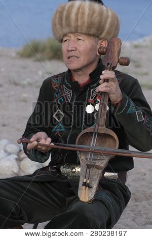 Issyk Kul, Kyrgyzstan - May 28, 2017 - Musician Plays Traditional Komuz Fretless Stringed Instrument