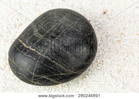 Zen Striped Black Stone On A Sea Sand Background