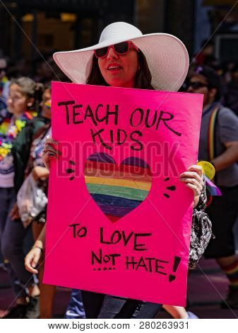 San Francisco, California, June 24, 2018:  Gay Pride Parade - Woman Marches With Sign Saying  Teach 