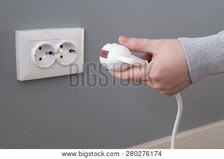 Hand Inserting Electrical Plug Into Outlet