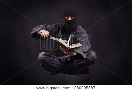 Ninja Levitation Reading A Book. Wisdom Concept. Ancient Warrior Hovers In The Air.