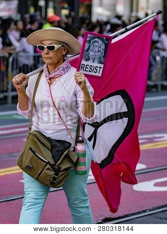 San Francisco, California, June 24, 2018:  Gay Pride Parade - Woman Marches With Resist Banner