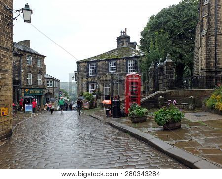 Howarth, West Yorkshire, England - 12 September 2018: Tourists Walking With Umbrellas On A Rainy Day