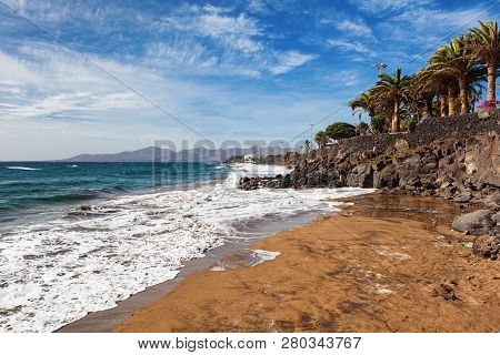 Puerto Del Carmen Beach In Lanzarote, Canary Islands, Spain. Blue Sea, Palm Trees, Selective Focus