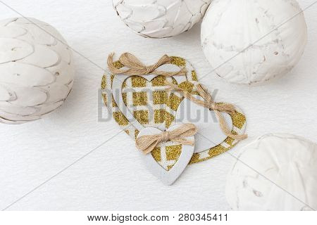 Three Paper Hearts White And Gold Colored In The Center Of Light Background With White Textile Textu