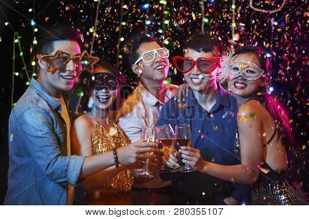 Happy Excited Young Vietnamese People In Party Glasses Posing With Champagne Glasses Under Fallling 