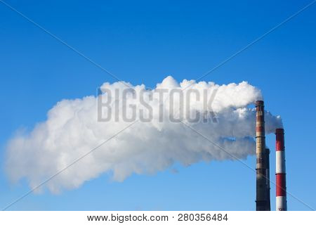 White Smoke Comes From Pipes Against Blue Sky. Problem Harmful Emissions And Air Pollution Of Centra