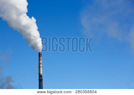 White Smoke Comes From Pipes Against Blue Sky. Problem Harmful Emissions And Air Pollution Of Centra