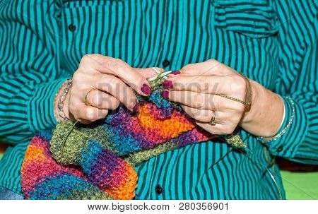 Needlework, Hands Of Old Woman Holding Knitting Needles And Multi Colored Wool For Woolwork Of Warm 