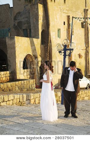 Neočekávané volání na mobilní telefon má přerušena šťastné chůze prewedding ženich a bri