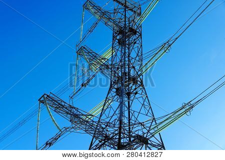 A Transmission Tower Or Electricity Pylon With Blue Sky. It Is A Tall Structure, Usually A Steel Lat