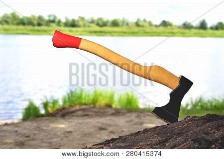 A Beautiful-shaped Ax Sticks Out In A Tree, With A Yellow Handle Close-up, On A Natural Background