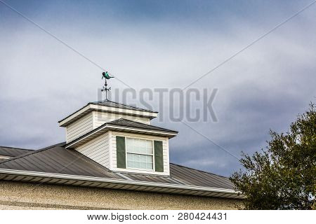 An Old Dolphin Windvane On A Wood And Copper Cupola On Old Building