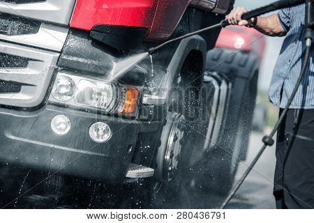 Semi Truck Pressure Washing By Caucasian Trucker. Automotive And Transport Industry.