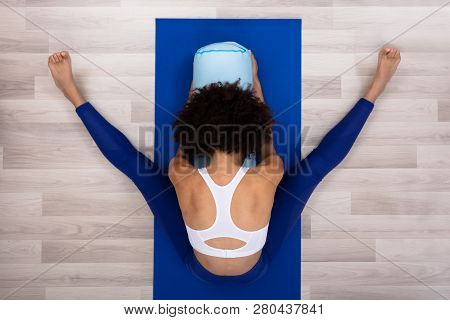 An Overhead View Of A Young Woman Sitting On Blue Exercise Mat Doing Yoga