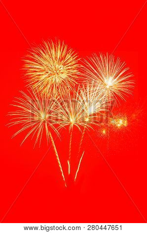 Golden Fireworks Celebration On Bright Red Background.