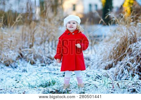 Outdoor Winter Portrait Of Little Cute Toddler Girl In Red Coat And White Fashion Hat Barret. Health
