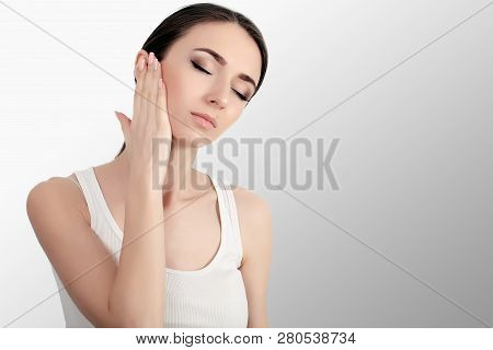 Woman In Pain. Closeup Of Beautiful Young Female Feeling Painful Toothache, Touching Face With Hand.