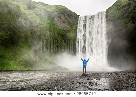 Single Man Standing Near Scogafoss Waterfall In Iceland And Spread His Hands. Travel Summer Nordic C