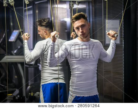 Muscular Young Man, Training Shoulders On Gym Machine