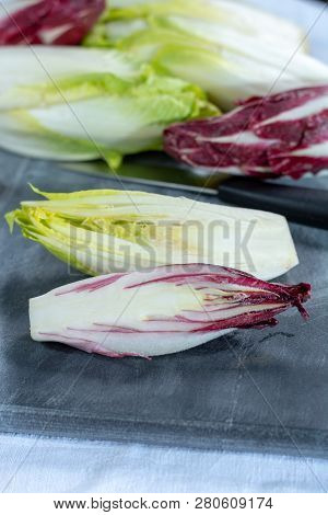 Group Of Fresh Green Belgian Endive Or Chicory And Red Radicchio Vegetables, Also Known As Witlof Sa