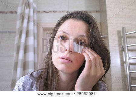 Tired Woken Woman With A Hangover Puts Patches On The Eyes In The Bathroom.