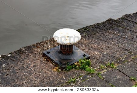 A Small White Metal Mooring Post On The Towpath On The Canal