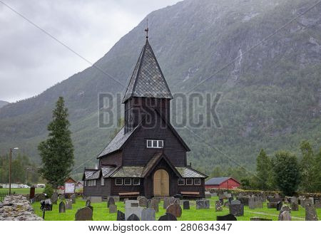 13th century wooden Roldal Stave Church (RÃ¸ldal stavkyrkje) and graveyard on a rainy day, Odda, Hordaland, Norway, Scandanavia