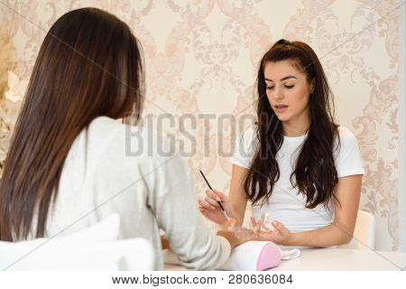 Close-up Of Beautician Applying Cream On Woman's Hand Using Brush.