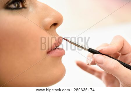 Makeup Artist Making Up Lips Of An African Young Woman