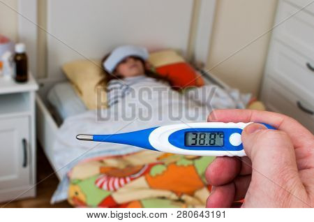Close Up On A Digital Thermometer  That Marks 38 Degrees Celsius.  Little Girl Into Bed With Wet Clo