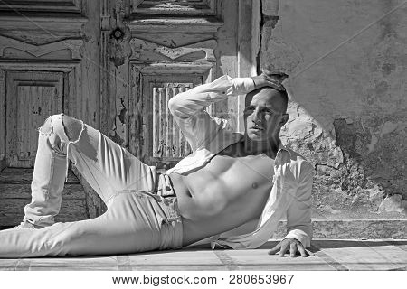 Sexy Macho Man With Bare Chest And Muscular Torso Relax At Wooden Door. Fashion Model In Jeand And S