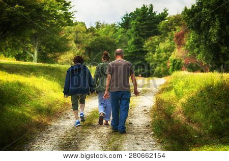 Litchfield, Connecticut.  September 9, 2017.  Grandparents Walking With Their Granddaughter On A Pat