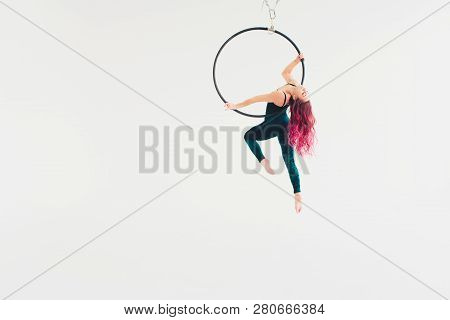 Aerial Acrobat In The Ring. A Young Girl Performs The Acrobatic Elements In The Air Ring.