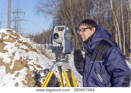 A Surveyor Enters The Survey Data For A Cadastre At A Construction Site During The Winter Period.