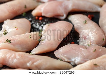 Raw Chicken Breast Mini Fillets In Rastic Cast Iron Skillet, Frying Pan With Herbs And Sea Salt