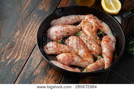 Raw Chicken Breast Mini Fillets In Rastic Cast Iron Skillet, Frying Pan With Herbs And Sea Salt