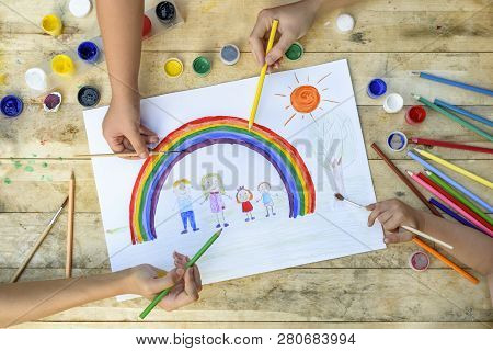 Happy Family Concept. Co-creation. Children Hands Draw On A Sheet Of Paper: Father, Mother, Boy And 