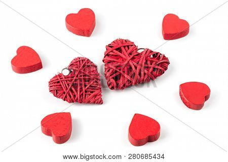 Group or red hearts isolated on white, six roughly carved wooden and two strawy