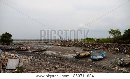 Harbor At Low Tide With Fishing Boats Waiting High Tide. Fishing Boats In Dry Harbour At Low Tide