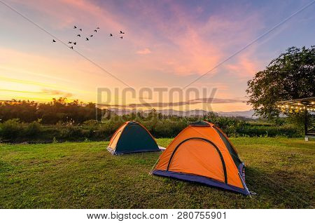 Travel To Spread The Tent In A Wide Open Space In The Evening. The Golden Sky Mountain Views On The 