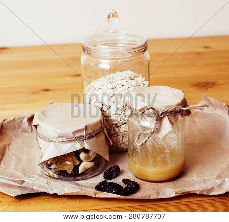 Real Comfort Wooden Kitchen With Breakfast Ingredients Close Up In Glass, Honey, Oatmeal, Milk, Mues