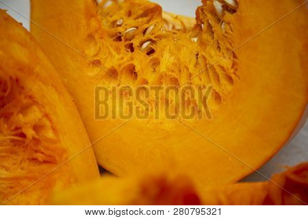 Slices Of Tasty And Healthy Vegetables - Juicy Bright And Orange Pumpkin With Seeds On The Table.