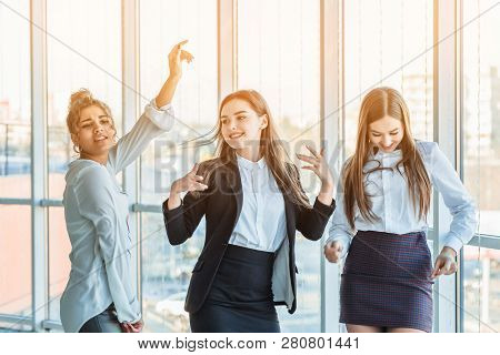 Three Young Beautiful Brunette Business Ladies In The Office. All Happy Dancing With