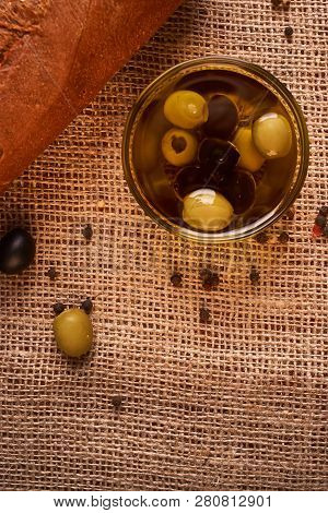 Fresh Bread Baguette With Olive Oil, Olives. Cheese And Rosemary On Wooden Background. Teasty Breakf